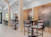 Thumbnail 26 of 76 - a seating area with tables and chairs in the lobby of a building at The Lodge at Overland, Rochester, Minnesota