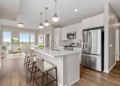 Thumbnail 15 of 57 - a white kitchen with a large island and stainless steel appliances