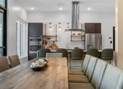 Thumbnail 29 of 76 - a kitchen and dining area with a wooden table and grey chairs at The Lodge at Overland, Minnesota, 55901
