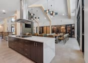 Thumbnail 36 of 76 - a kitchen with an island and a dining room in the background at The Lodge at Overland, Rochester, Minnesota