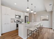 Thumbnail 14 of 57 - a white kitchen with a large island with chairs