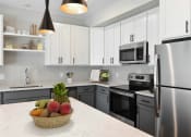 Thumbnail 69 of 76 - a kitchen with stainless steel appliances and white cabinets at The Lodge at Overland, Rochester