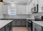 Thumbnail 57 of 76 - a kitchen with white countertops and gray cabinets at The Lodge at Overland, Rochester, MN