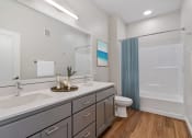 Thumbnail 24 of 57 - a bathroom with two sinks and a toilet and a shower
