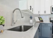 Thumbnail 70 of 76 - a white kitchen with a stainless steel sink and white cabinets  at The Lodge at Overland, Rochester, Minnesota