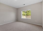 Thumbnail 60 of 76 - a bedroom with a large window and beige carpet at The Lodge at Overland, Minnesota, 55901