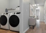 Thumbnail 73 of 76 - a washer and dryer in a laundry room with a sink and a mirror at The Lodge at Overland, Rochester, MN, 55901