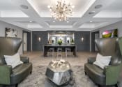 Thumbnail 20 of 30 - a living room with two leather chairs and a bar and a chandelier at Park 205, Illinois, 60068