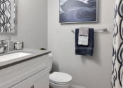 Thumbnail 10 of 30 - a bathroom with a sink and a toilet and a towel rack and a shower curtain