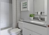 Thumbnail 7 of 30 - a small bathroom with a sink and toilet and a shower curtain