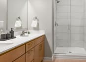 Thumbnail 11 of 62 - a bathroom with two sinks and a shower at The Aurilla in Cottage Grove, Minnesota