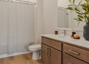 Thumbnail 78 of 83 - A bathroom with a toilet, sink, and a plant.