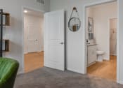 Thumbnail 10 of 42 - a living room with an open door to a bathroom and a closet at The View on Collins, Michigan