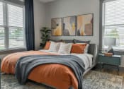 Thumbnail 4 of 79 - an orange and gray bedroom with a bed and two windows at The Commons at Rivertown, Grandville, 49418