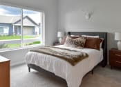 Thumbnail 5 of 76 - a bedroom with a bed and a large window at The Lodge at Overland, Rochester, MN, 55901