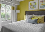 Thumbnail 8 of 30 - a bedroom with yellow walls and a bed with pillows