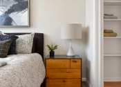 Thumbnail 15 of 42 - a bedroom with a bed and a night stand with a lamp at The View on Collins, Lansing, MI, 48910