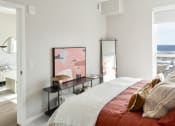 Thumbnail 12 of 57 - a bedroom with a bed and a desk with a mirror