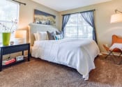 Thumbnail 22 of 43 - a bedroom with a large bed and a chair next to a window  at Riverset Apartments, Tennessee, 38103