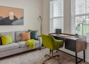 Thumbnail 9 of 42 - a living room with a couch and a desk with a chair at The View on Collins, Lansing, Michigan