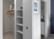 Thumbnail 6 of 30 - a closet in a small room with shelves and a television