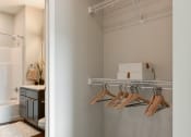 Thumbnail 10 of 57 - a bathroom with a closet and a rack with wooden hangers