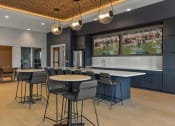 Thumbnail 16 of 79 - a communal area with tables and chairs and a tv in a clubhouse at The Commons at Rivertown, Grandville, Michigan