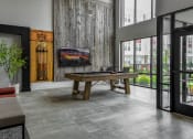 Thumbnail 22 of 42 - a pool table in a living room with a large glass door at The View on Collins, Lansing, Michigan