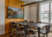 Thumbnail 28 of 42 - a conference room with a table and chairs and a large window at The View on Collins, Lansing