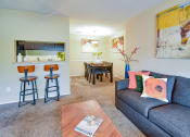 Thumbnail 18 of 43 - a living room with a couch and a table with stools  at Riverset Apartments, Tennessee