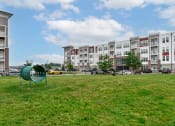 Thumbnail 42 of 42 - an open field with an apartment building in the background at The View on Collins, Michigan, 48910