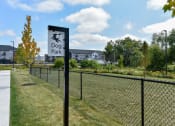 Thumbnail 24 of 79 - a dog park sign in front of a chain link fence at The Commons at Rivertown, Grandville, MI, 49418