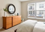 Thumbnail 9 of 22 - a bedroom with a bed and a dresser and a window