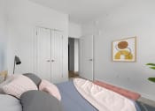 Thumbnail 12 of 83 - a bedroom with a bed and a closet and a painting on the wall