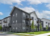 Thumbnail 29 of 79 - an exterior view of an apartment building on a city street at The Commons at Rivertown, Grandville, Michigan