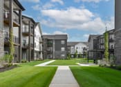 Thumbnail 30 of 79 - an exterior view of an apartment complex with a green lawn at The Commons at Rivertown, Grandville, MI, 49418