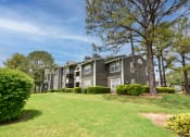 Thumbnail 43 of 43 - an apartment building on a grassy hill with trees in the background at Riverset Apartments in Mud Island, Memphis, TN