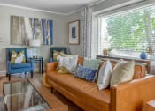 Thumbnail 27 of 30 - a living room with a brown leather couch and blue chairs