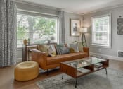 Thumbnail 26 of 30 - a living room with a leather couch and a coffee table