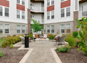 Thumbnail 40 of 42 - an outdoor living area with a fire pit in front of an apartment building  at The View on Collins, Lansing, MI, 48910