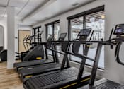 Thumbnail 48 of 83 - A gym with treadmills and a view of the street outside.