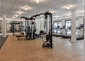 Thumbnail 53 of 83 - A gym with a variety of equipment including treadmills, weights, and exercise machines.