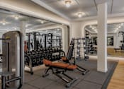 Thumbnail 49 of 83 - A gym with a variety of equipment including weights and machines.