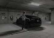 Thumbnail 70 of 83 - A man is charging an electric car in a parking garage.