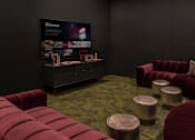 Thumbnail 47 of 83 - A room with a red couch and ottoman in front of a black wall with a poster on it.