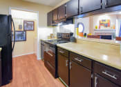 Thumbnail 19 of 43 - a kitchen with black cabinets and wood floors  at Riverset Apartments, Memphis