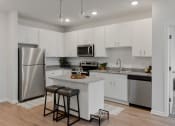 Thumbnail 1 of 42 - spacious kitchen with stainless steel appliances and island with two stools at The View on Collins, Michigan, 48910