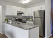 Thumbnail 1 of 30 - a kitchen with stainless steel appliances and white cabinets