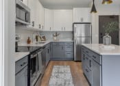 Thumbnail 2 of 76 - a kitchen with gray and white cabinets and stainless steel appliances at The Lodge at Overland, Rochester, 55901