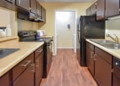 Thumbnail 21 of 43 - a kitchen with a black refrigerator freezer next to a stove top oven  at Riverset Apartments, Tennessee